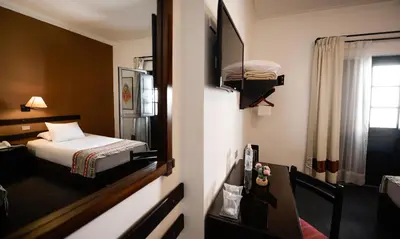 a hotel room with a bed and a window at Hotel Raymi in Cusco