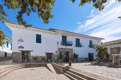 a large white building with blue shuttered windows at Casa Andina Premium Cusco in Cusco