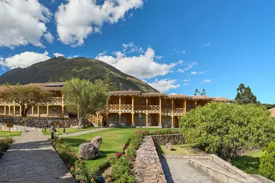 a building with a mountain in the background at Casa Andina Premium Valle Sagrado Hotel & Villas in Urubamba