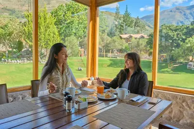 two women sitting at a table in a restaurant at Casa Andina Premium Valle Sagrado Hotel & Villas in Urubamba