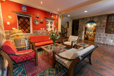 a living room with red walls and a couch and chairs at Amerindia in Cusco