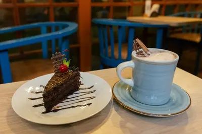 a piece of cake on a plate next to a cup of coffee at Amerindia in Cusco