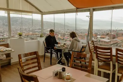 a man and woman sitting at a table in a restaurant at Cozy Room Cusco in Cusco