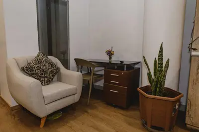 a room with a chair and a desk with a plant at Cozy Room Cusco in Cusco