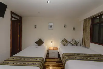 two beds sitting next to each other in a room at Cozy Room Cusco in Cusco