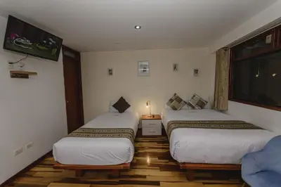 two twin beds in a room with a window at Cozy Room Cusco in Cusco