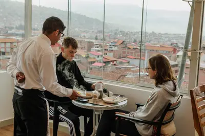 a group of people sitting around a table in a restaurant at Cozy Room Cusco in Cusco