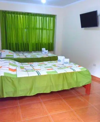 a bed in a room with a green curtain at Maudi Lodging in La Merced