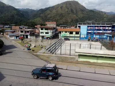a blue truck driving down a street in a town at Maudi Lodging in La Merced