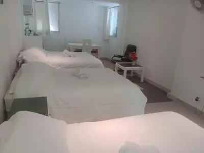 two beds in a room with white sheets at Monterrico Suites Hotel in Lima