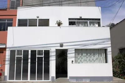 a white house with a garage at Monterrico Suites Hotel in Lima