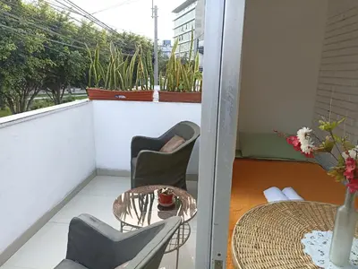 a balcony with a table and chairs and a table and a window at Monterrico Suites Hotel in Lima