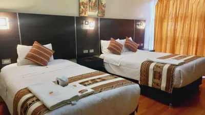 a hotel room with two beds with towels on them at Hotel Mantas Cusco in Cusco