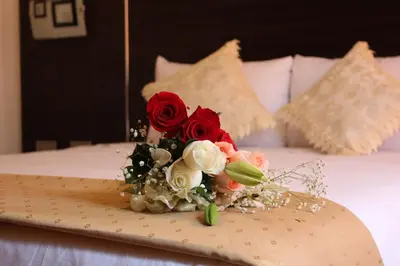 a bouquet of red and white flowers on a bed at Hotel Mantas Cusco in Cusco