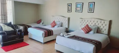 a hotel room with three beds and a chair at Hotel Mantas Cusco in Cusco