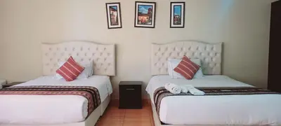 two beds sitting next to each other in a room at Hotel Mantas Cusco in Cusco