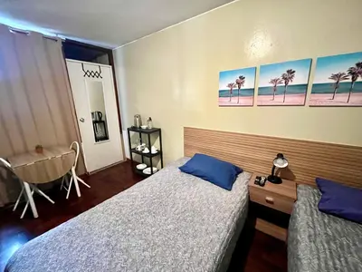 a bedroom with two beds and a chair in it at Lima Mini Aparts Monterrico - Cerca Embajada EEUU in Lima