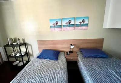 two beds in a room with palm trees on the wall at Lima Mini Aparts Monterrico - Cerca Embajada EEUU in Lima
