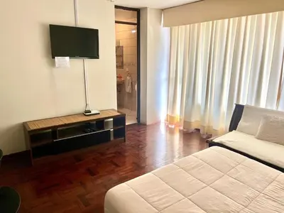a hotel room with a bed and a television at Lima Mini Aparts Monterrico - Cerca Embajada EEUU in Lima