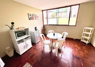 a kitchen with a table and chairs and a microwave at Lima Mini Aparts Monterrico - Cerca Embajada EEUU in Lima