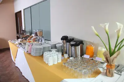 a buffet line with plates and bottles and drinks at Hotel Rivera Inn in Lima