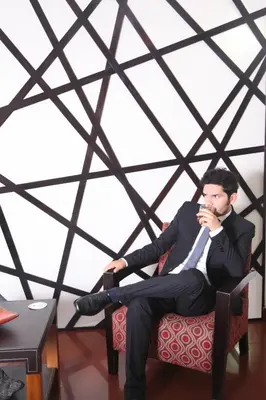 a man in a suit sitting in a chair at Hotel Rivera Inn in Lima