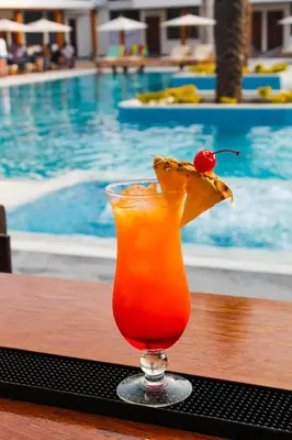 a drink sitting on a table next to a pool at Resort la Fogata Cieneguilla in Cieneguilla