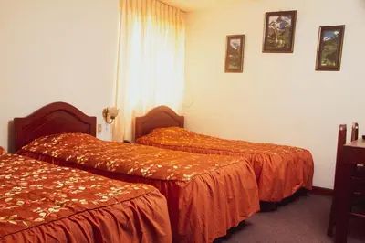 a hotel room with two beds with orange sheets at Hotel Internacional in Lima