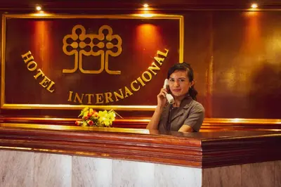 a woman talking on a cell phone at a bar at Hotel Internacional in Lima