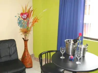 a table with wine glasses and a vase at Septima Maravilla in Lima