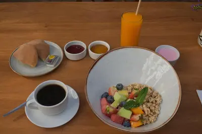 a table with a bowl of food and a cup of coffee at Nodo Cusco Garcilaso in Cusco