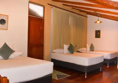 a room with two beds in a room at Nodo Cusco Garcilaso in Cusco