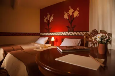 a hotel room with two beds and a desk with a table at Eureka San Blas in Cusco