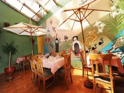 a dining room with a table and chairs with umbrellas at Eureka San Blas in Cusco