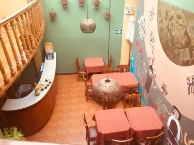 a restaurant with tables and chairs and a staircase at Eureka San Blas in Cusco