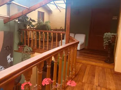 a staircase in a house with wooden floors and flowers at Eureka San Blas in Cusco