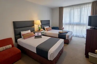 a hotel room with two beds and a television at La Paz Apart Hotel in Lima