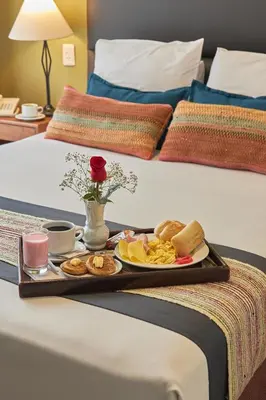 a tray of breakfast foods on a bed at La Paz Apart Hotel in Lima