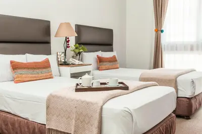 a hotel room with two beds with a tray on top at La Paz Apart Hotel in Lima