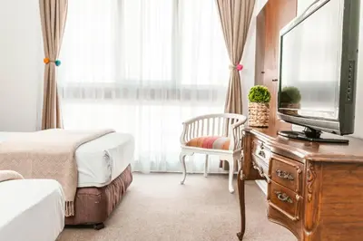 a hotel room with two beds and a television at La Paz Apart Hotel in Lima