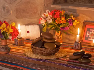 a basket of rocks on a table with candles and flowers at Willka T'ika in Urubamba