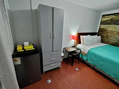 a bedroom with a bed and a cabinet and a table at Casita Libertad Chorrillos in Lima