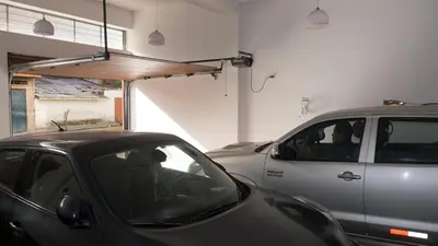 a car parked in a garage next to a silver car at Hotel Shelter in Huancayo