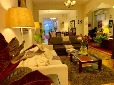 a living room with a white couch and a table at Casa Bella Boutique Hotel San Isidro in Lima
