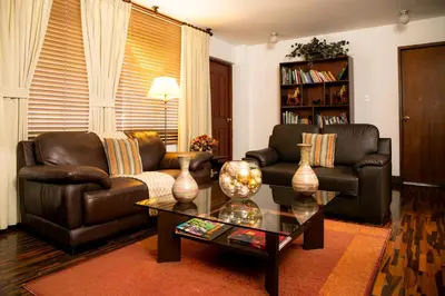 a living room with two leather couches and a coffee table at Casa Bella Boutique Hotel San Isidro in Lima