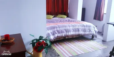 a bedroom with a bed and a table at La Casa del Che Fernando in Lima