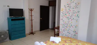 a bedroom with a bed and a tv and a dresser at La Casa del Che Fernando in Lima