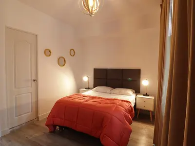 a bedroom with a bed with a red blanket at Alpes Lima Kennedy Hostel in Lima