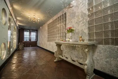 a hallway with a table with flowers on a wall at Casa Cavassa Centro Histórico Cusco in Cusco