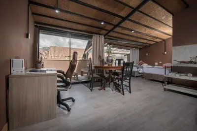 a living room with a table and chairs and a bedroom at Casa Cavassa Centro Histórico Cusco in Cusco